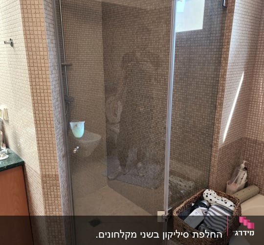 מקלחת עם דלת זכוכית וראש מקלחת מרובע